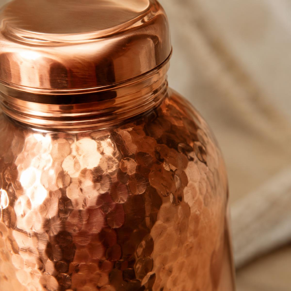 Detail of a hammered copper bottle surface and cap
